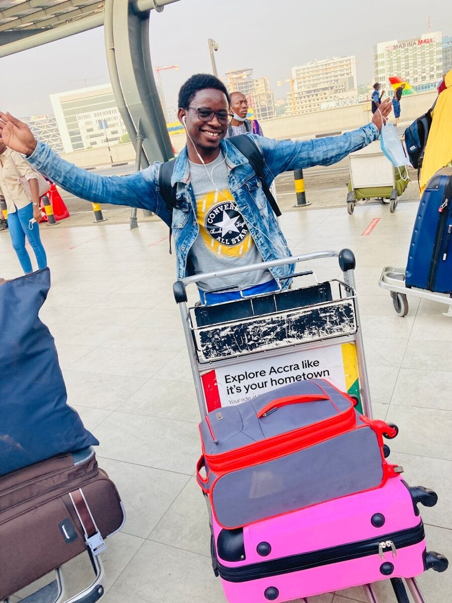 a man standing next to a cart filled with luggage