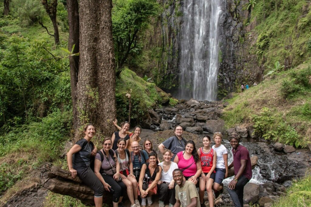 Home 17 A group of people posing in front of a waterfall